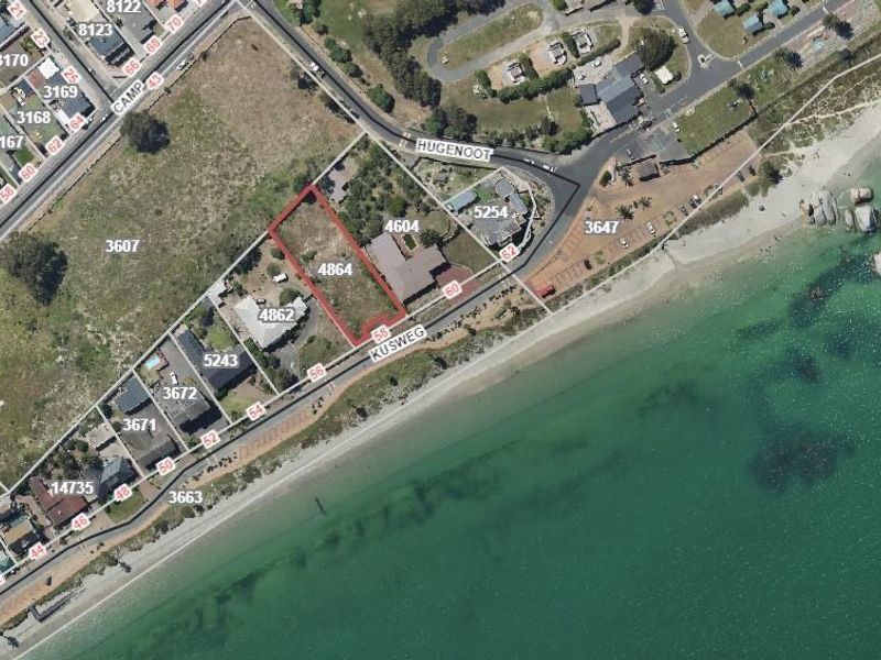 Aerial view of a vacant residential land parcel situated in a prime beachfront location with direct coastal access.