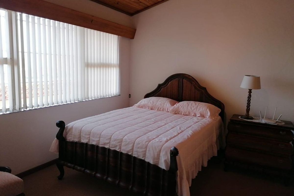 A bedroom featuring a timber-clad ceiling and vertical blinds, providing a neutral space ready for personalization.