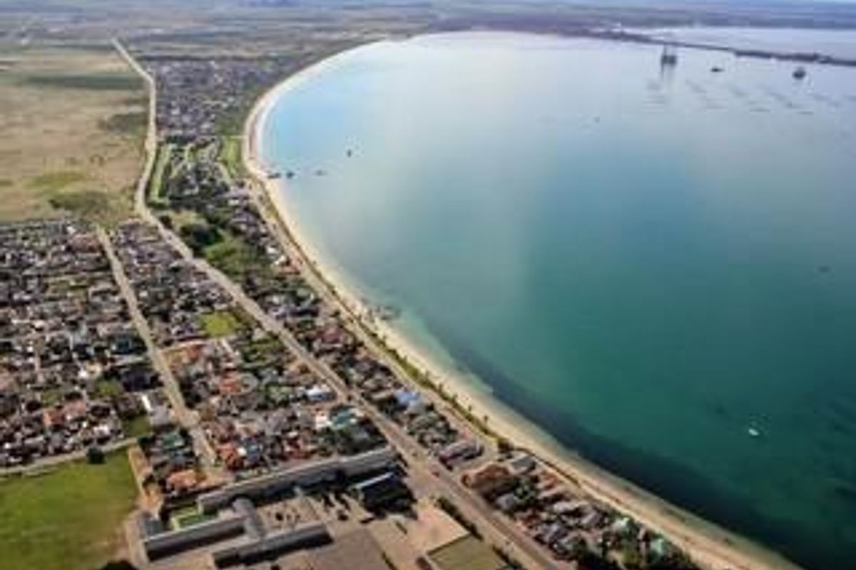 An aerial view of the coastal residential area, showcasing the proximity to the beach and the surrounding urban layout.