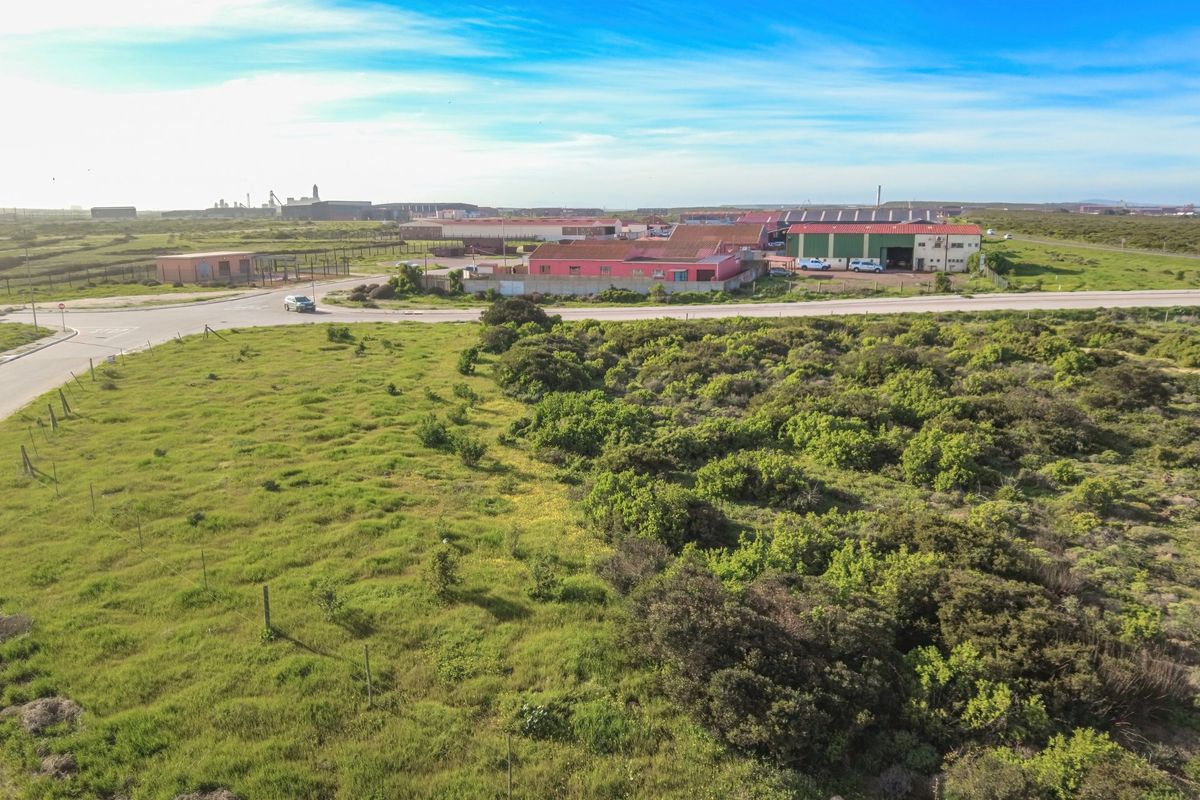 Aerial view of the industrial property site, showcasing surrounding landscape, access roads, and proximity to existing warehouse facilities.