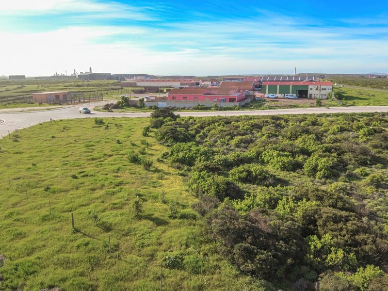 Aerial view of the industrial property site, showcasing surrounding landscape, access roads, and proximity to existing warehouse facilities.