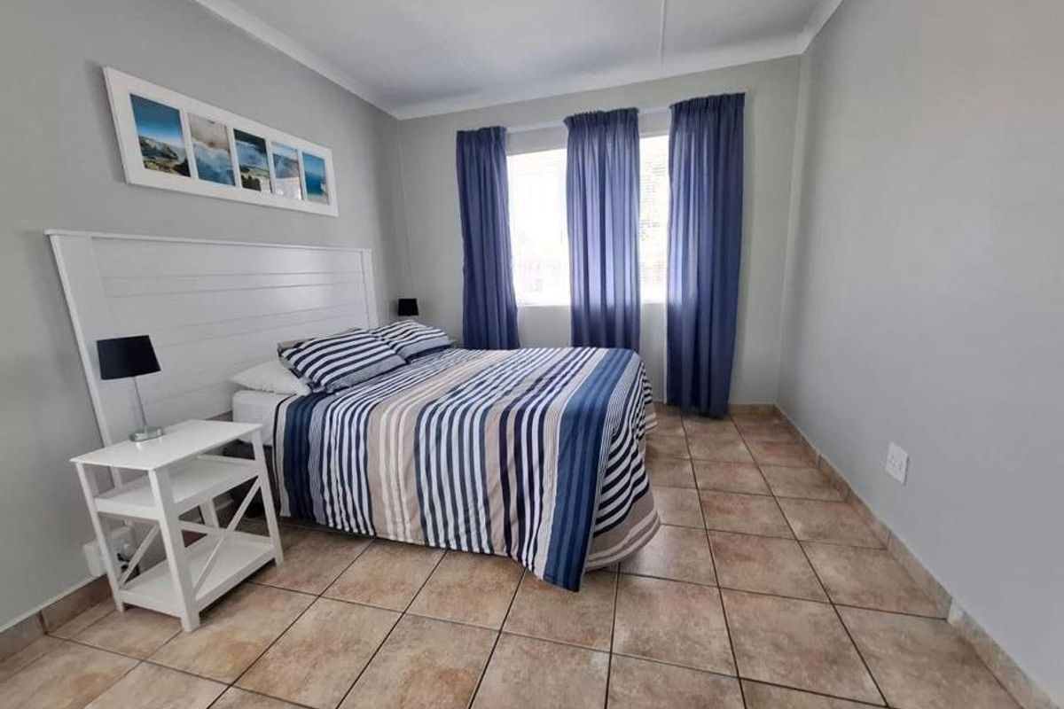 A bedroom featuring tiled flooring and neutral wall finishes, providing a functional and well-maintained space.