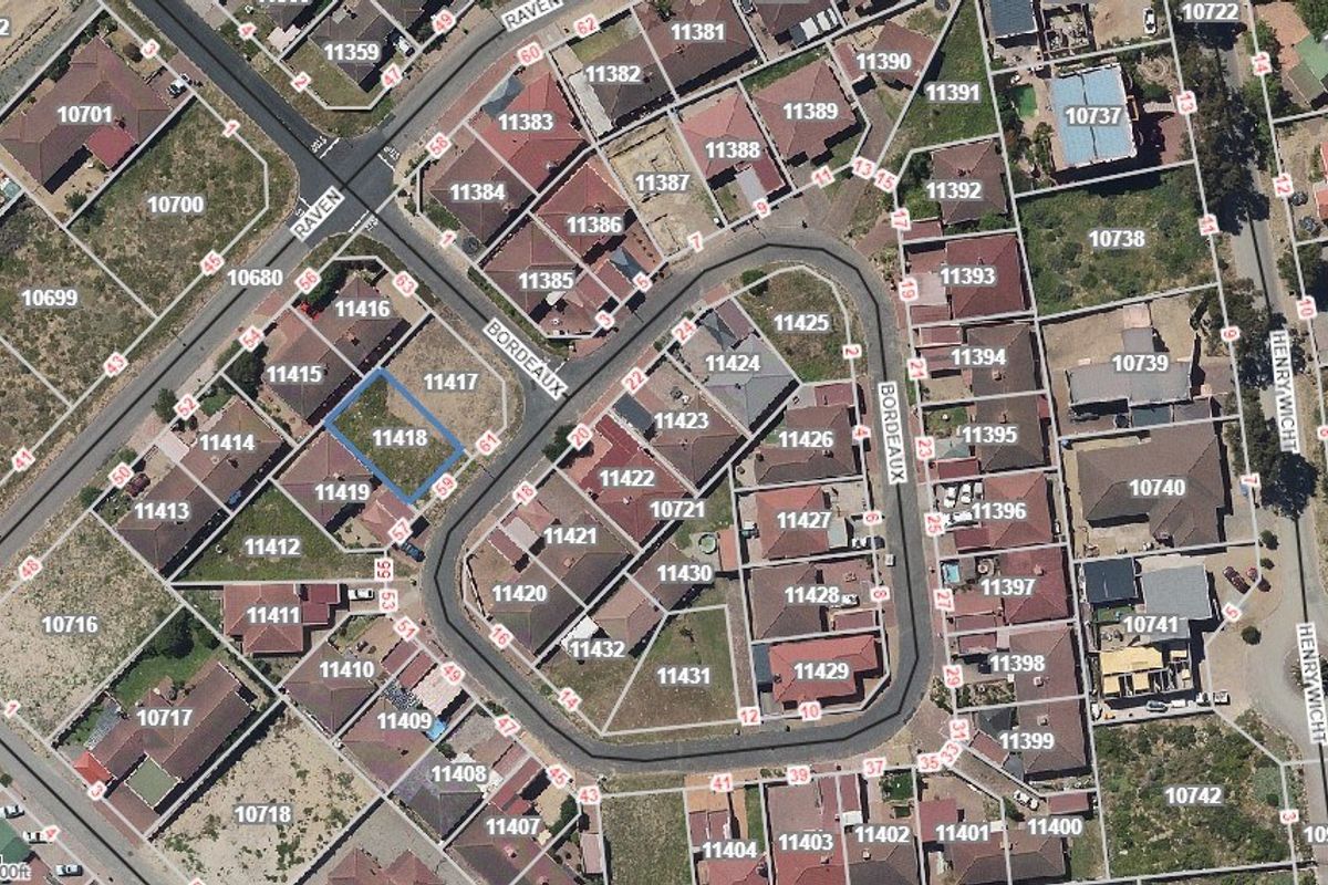 Aerial view of a vacant residential plot located within a developed suburban estate, showing surrounding properties and street access.