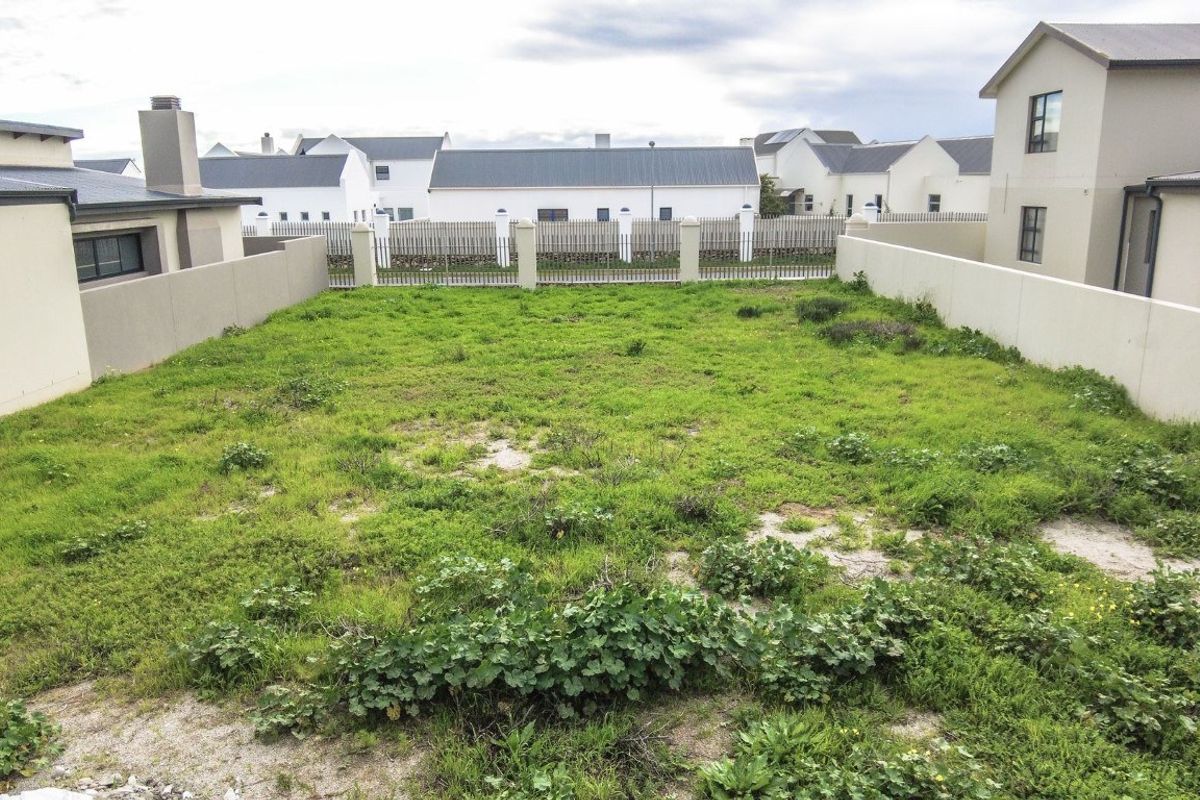 A vacant residential plot featuring perimeter boundary walls and established fencing, offering a clear space for future development.
