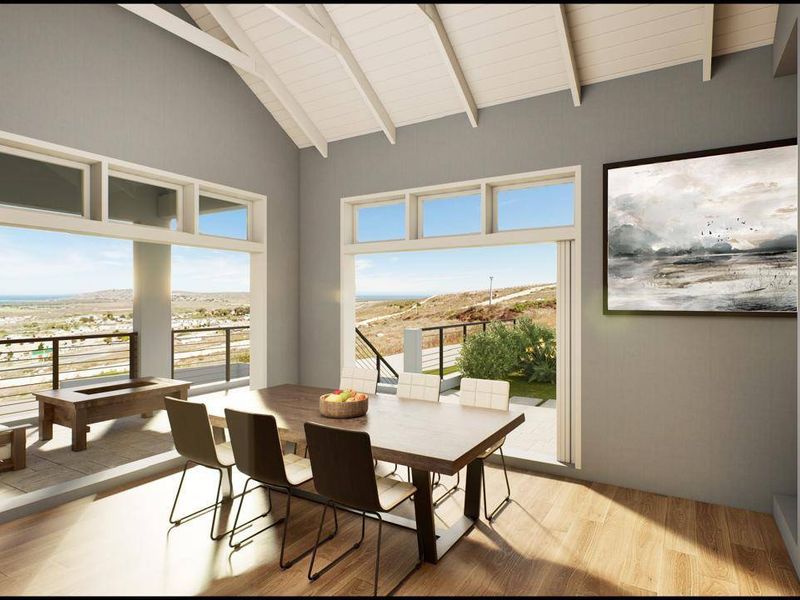 A bright dining area featuring a vaulted ceiling, built-in fireplace, and large sliding glass doors that open to a scenic outdoor view.