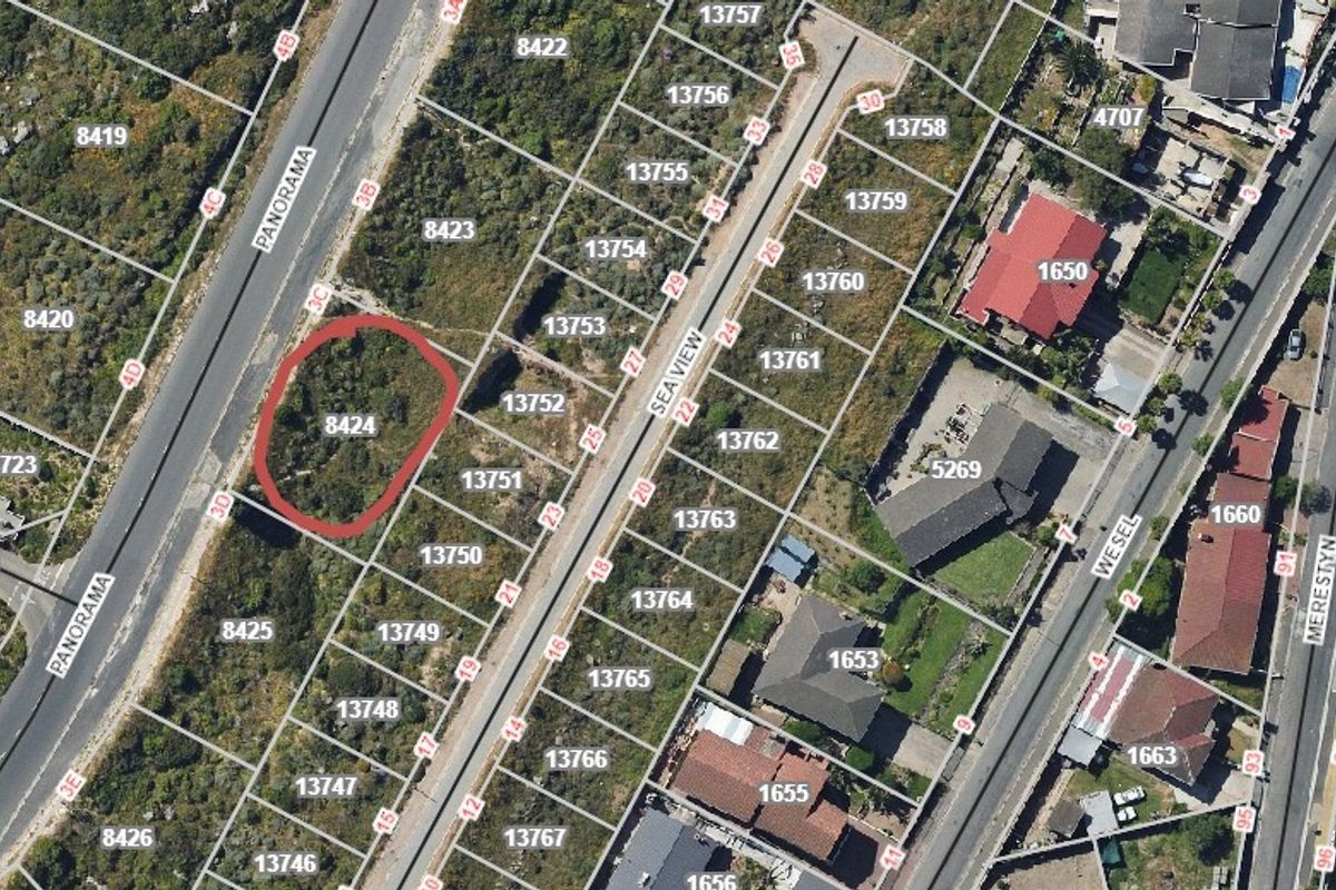 Aerial view of vacant residential plot 8424, situated in a developed neighborhood with established road access and surrounding properties.