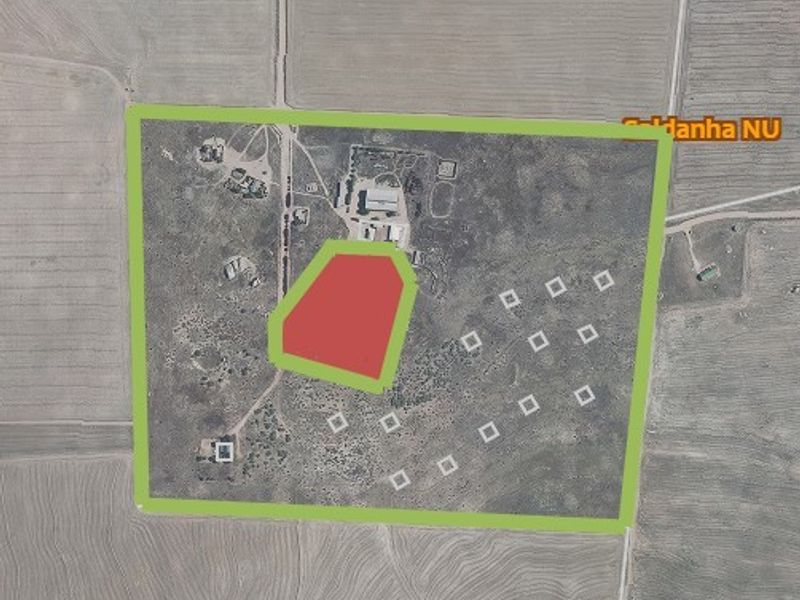 Aerial view of a large vacant residential land plot with marked boundaries and site layout indicators.