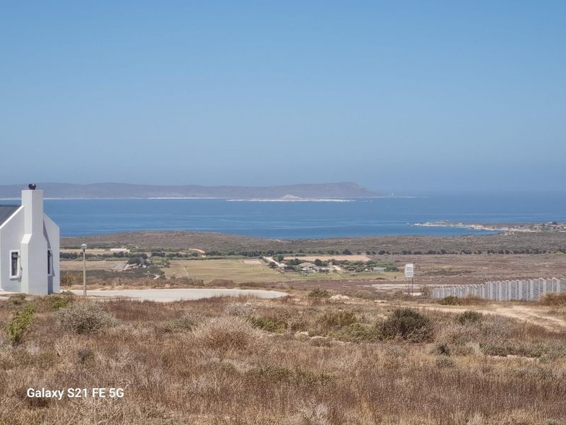 A scenic elevated view overlooking the coastal landscape and ocean, showcasing the natural surroundings of the vacant residential land.