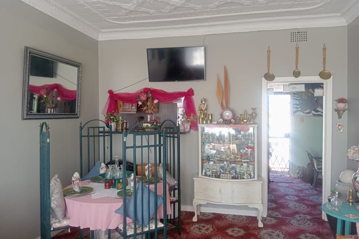 A living room featuring an ornate ceiling with decorative coving and a neutral wall finish, providing a traditional foundation for the space.