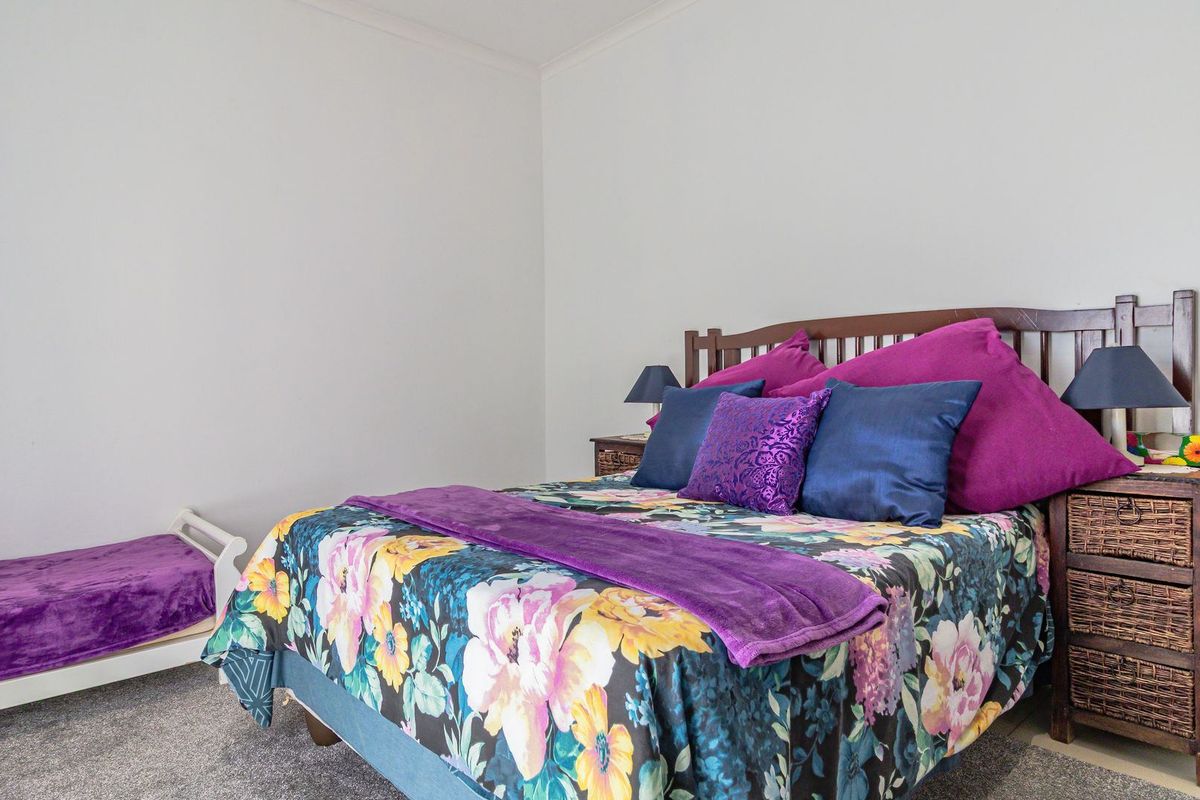 A well-lit bedroom featuring neutral wall finishes, carpeted flooring, and coved ceiling detailing, providing a comfortable and functional sleeping space.