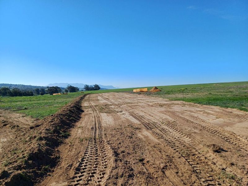 A view of an undeveloped industrial plot featuring cleared earth and open land, suitable for future construction or development.