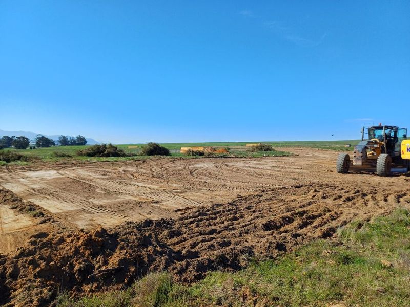 A wide-angle view of a cleared industrial development site showing ongoing earthworks and preparation for construction.