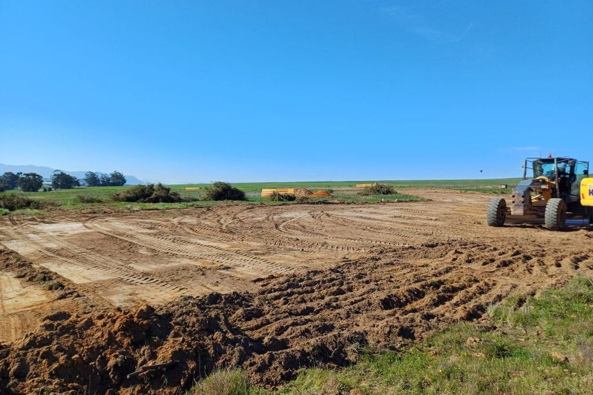 A wide-angle view of a cleared industrial development site showing ongoing earthworks and preparation for construction.
