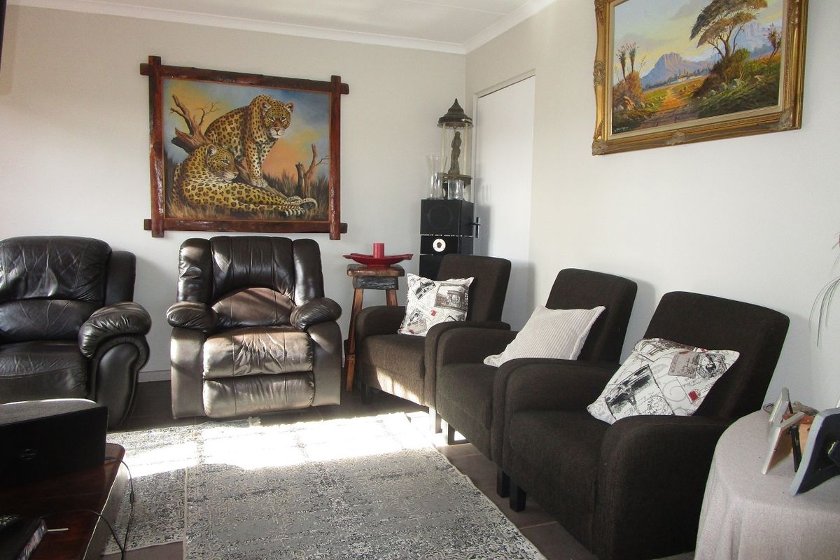 A comfortable living room space featuring neutral wall finishes and tiled flooring, suitable for relaxation and family gatherings.