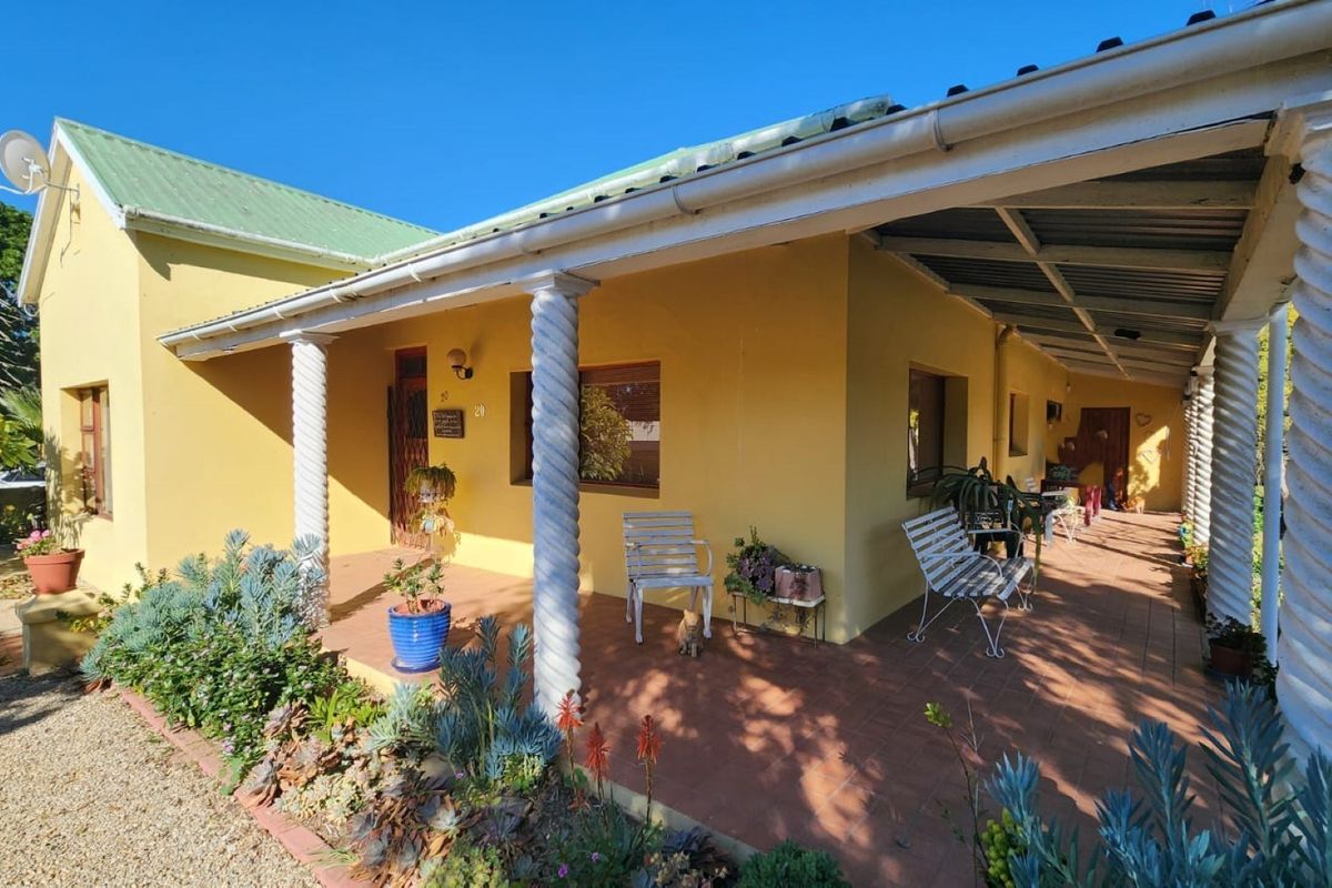 A covered patio area featuring decorative columns and tiled flooring, providing a sheltered outdoor space along the side of the house.