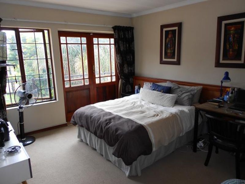 A bedroom featuring carpeted flooring, coving, and wooden framed glass doors providing access to an outdoor area.