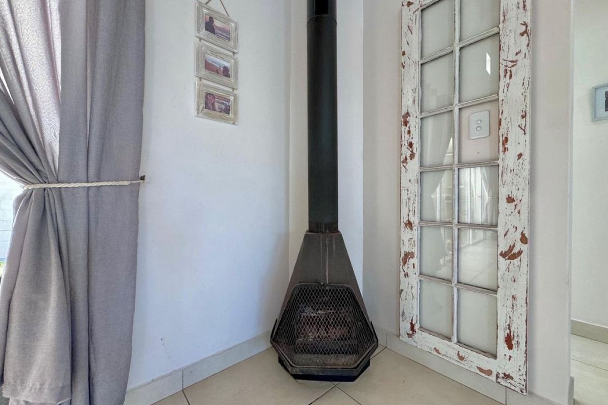 A corner living area featuring a freestanding metal fireplace with a flue pipe and a decorative distressed-finish french door.
