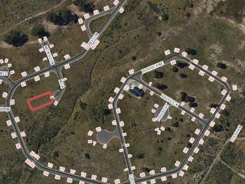 Aerial view of a vacant residential land plot highlighted in red, situated within a developed estate with established road infrastructure.
