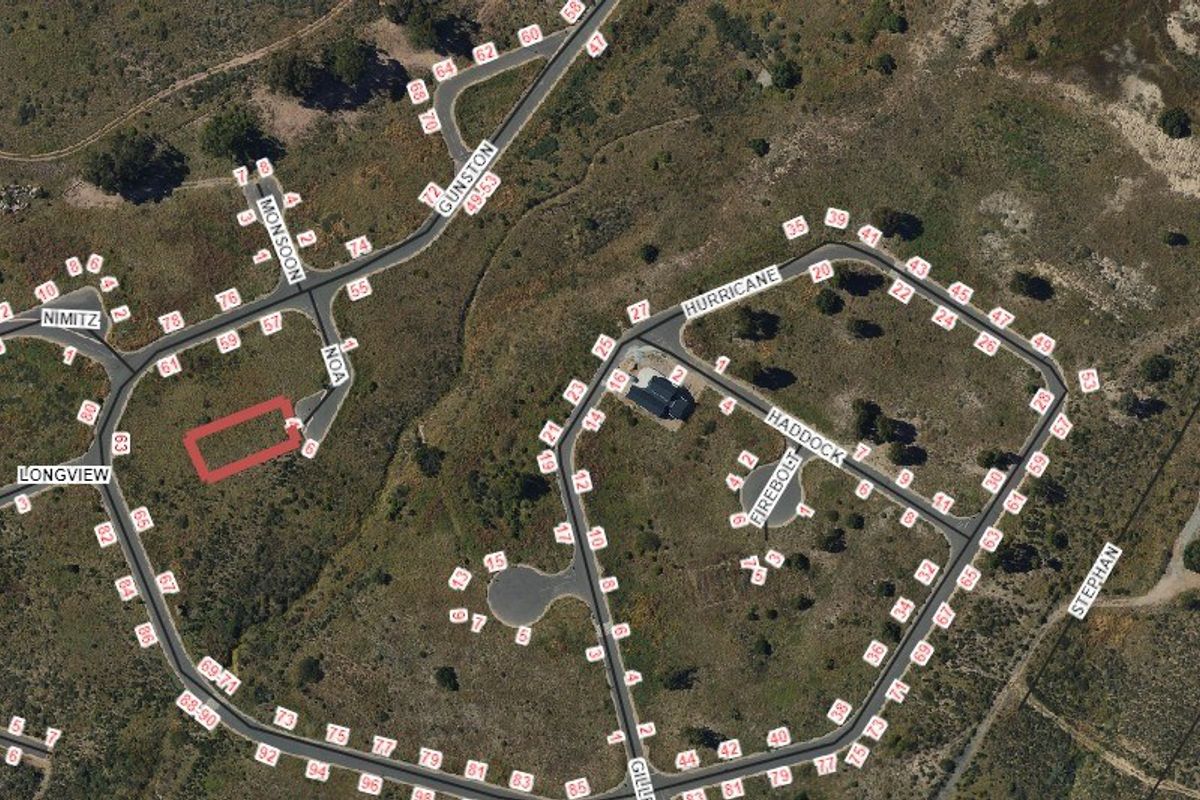 Aerial view of a vacant residential land plot highlighted in red, situated within a developed estate with established road infrastructure.