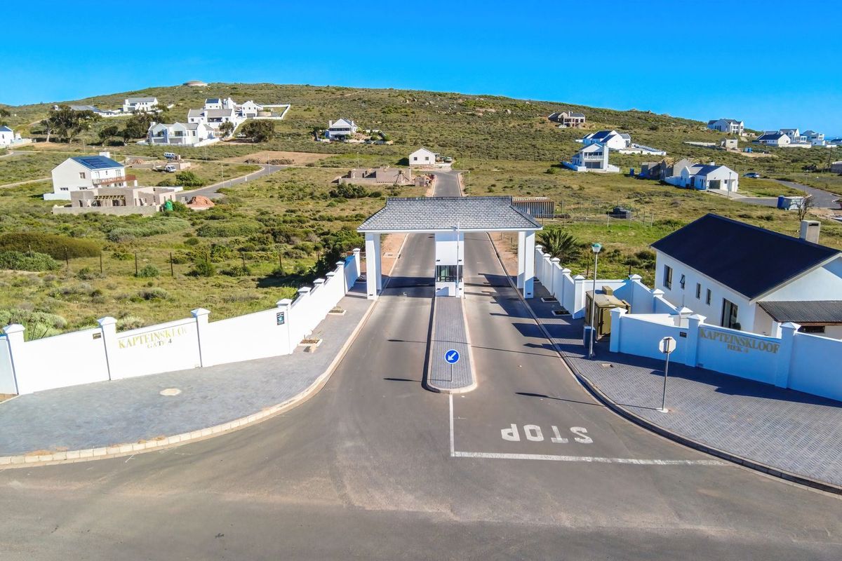 Aerial view of the secure gated entrance to the residential estate, featuring a paved driveway, security gatehouse, and surrounding perimeter walls.