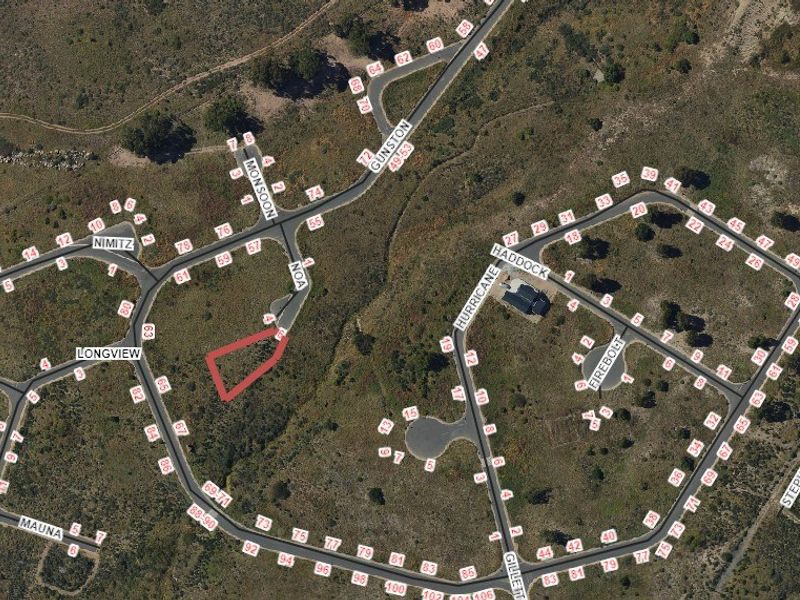 An aerial view of a residential estate showing the location of the vacant land plot highlighted in red.