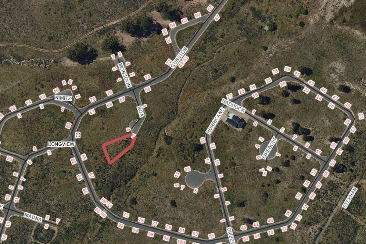 An aerial view of a residential estate showing the location of the vacant land plot highlighted in red.