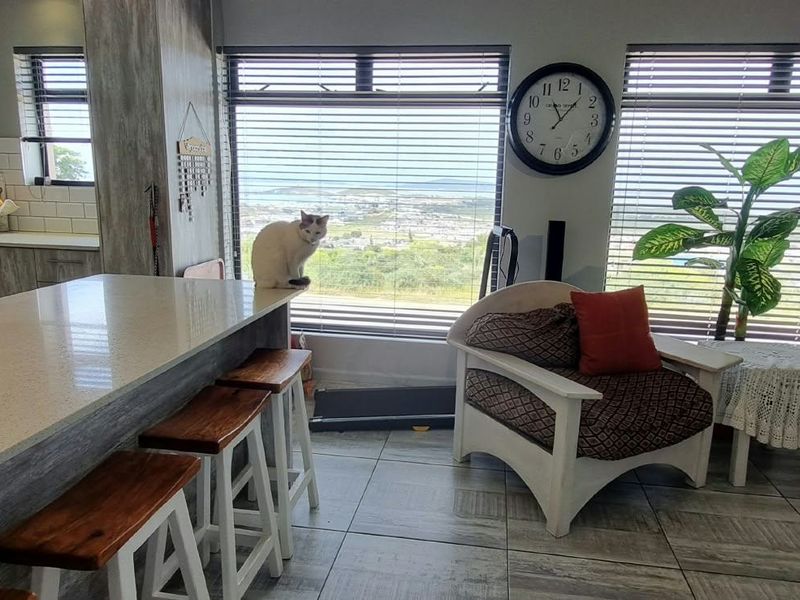 Open-plan kitchen and living area featuring quartz countertops, subway tile backsplash, and large windows with scenic views.