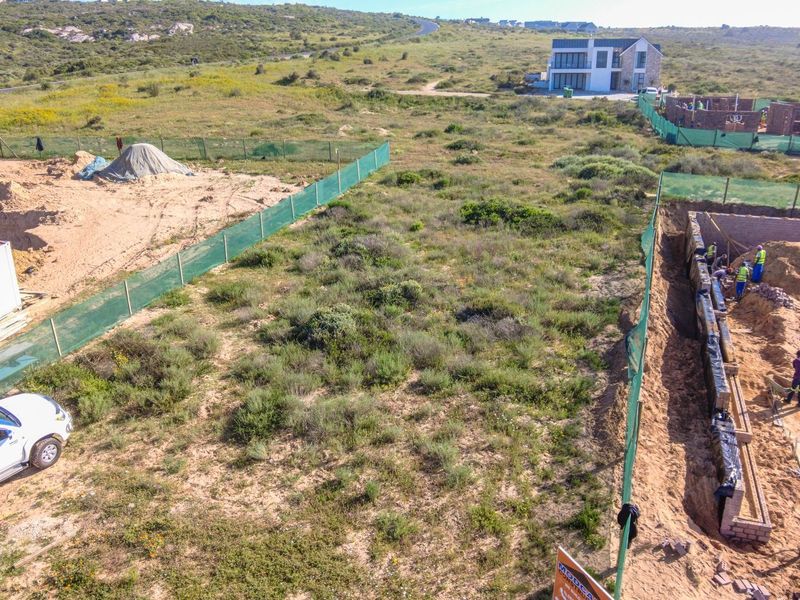 Aerial view of a residential vacant land plot currently undergoing foundation excavation and construction work.