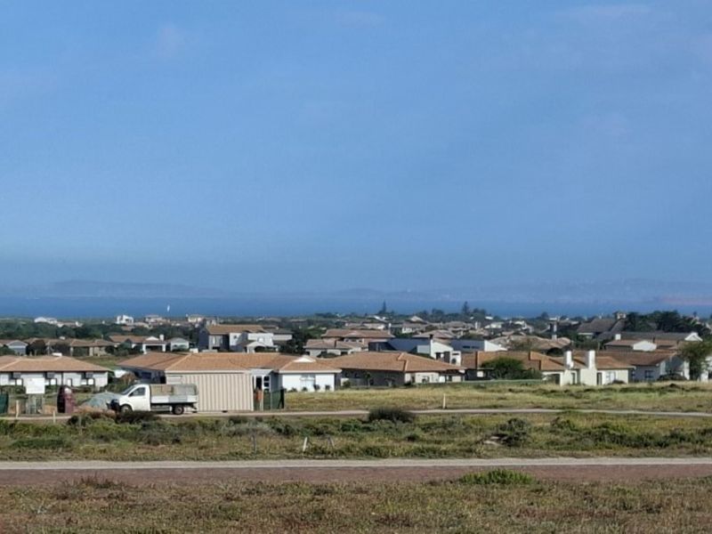 A wide-angle view overlooking a residential neighborhood with a distant coastal horizon.