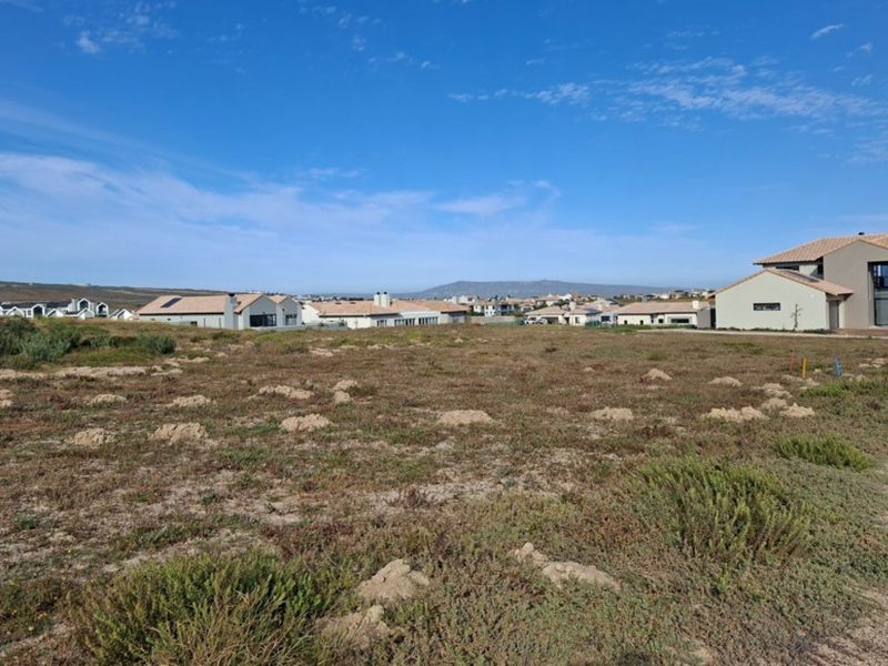 A vacant residential plot of land situated in a developed estate, offering a clear building site with surrounding residential properties.