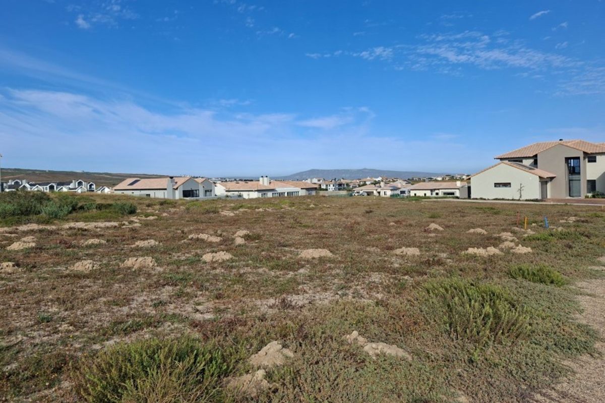 A vacant residential plot of land situated in a developed estate, offering a clear building site with surrounding residential properties.