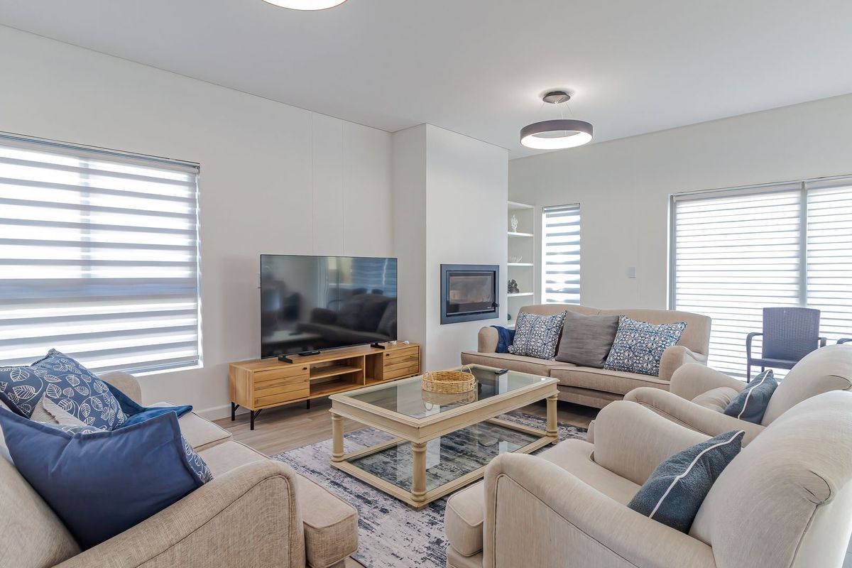 A bright and spacious living room featuring a built-in fireplace, recessed shelving, and large sliding glass doors that provide ample natural light.