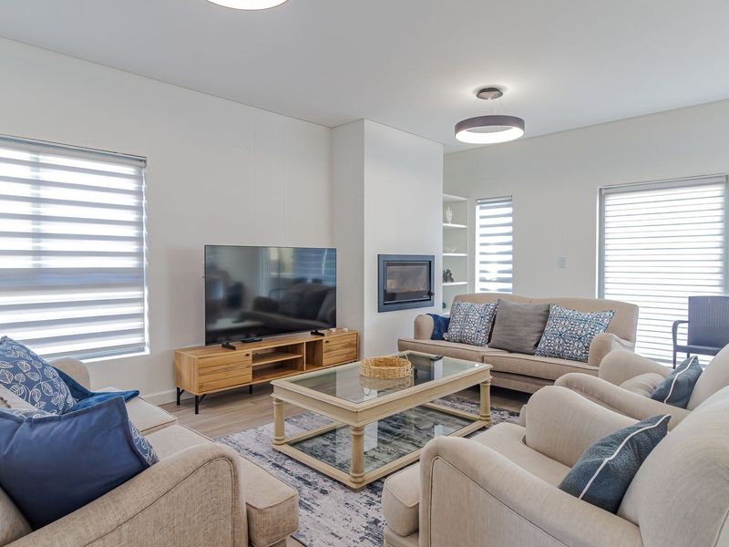 A bright and spacious living room featuring a built-in fireplace, recessed shelving, and large sliding glass doors that provide ample natural light.