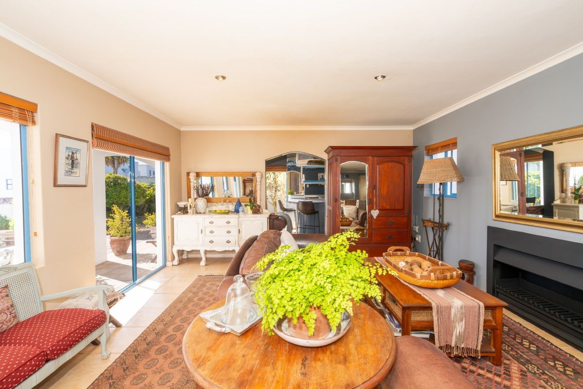 A spacious living room featuring tiled flooring, a built-in fireplace, and large sliding glass doors that provide direct access to the outdoor patio area.