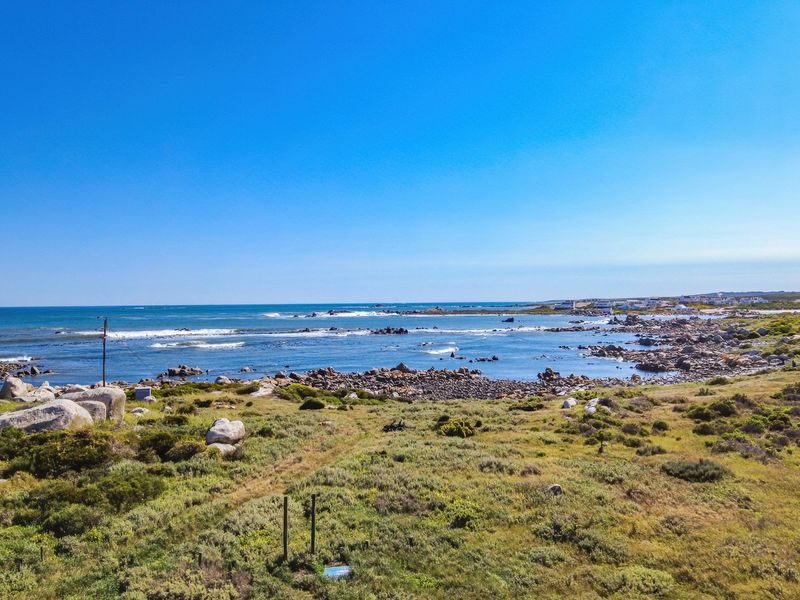 A scenic elevated view of the coastal landscape, featuring natural rocky terrain and direct ocean frontage.