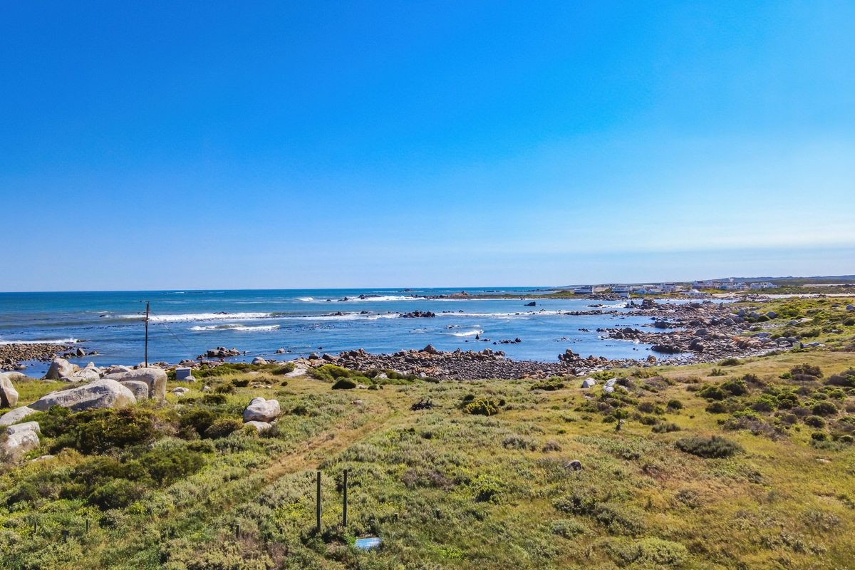A scenic elevated view of the coastal landscape, featuring natural rocky terrain and direct ocean frontage.