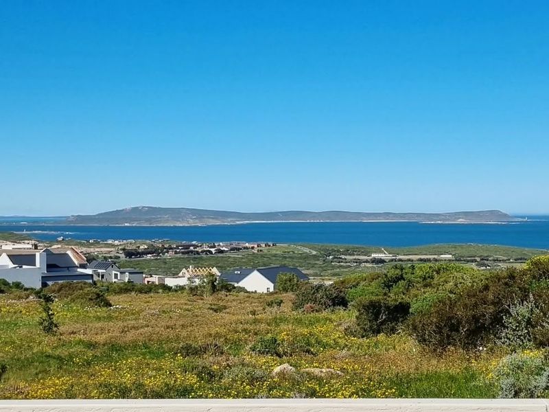 A scenic elevated view overlooking the coastal landscape, surrounding residential properties, and the ocean horizon.