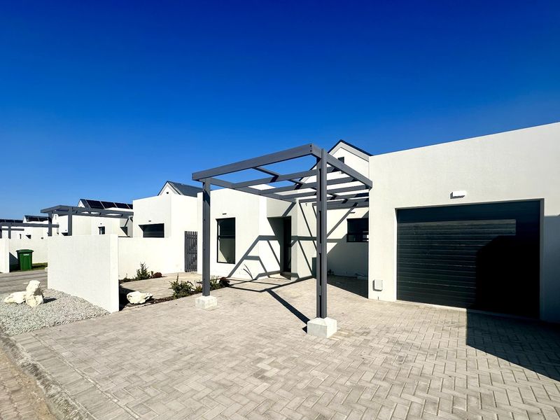Modern front elevation featuring a paved driveway, a contemporary metal pergola structure, and a single garage door in a clean, minimalist residential setting.