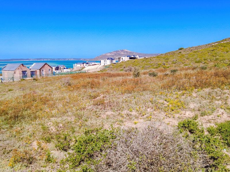 A scenic view of the coastal landscape and surrounding residential area, showcasing the natural terrain and proximity to the water.