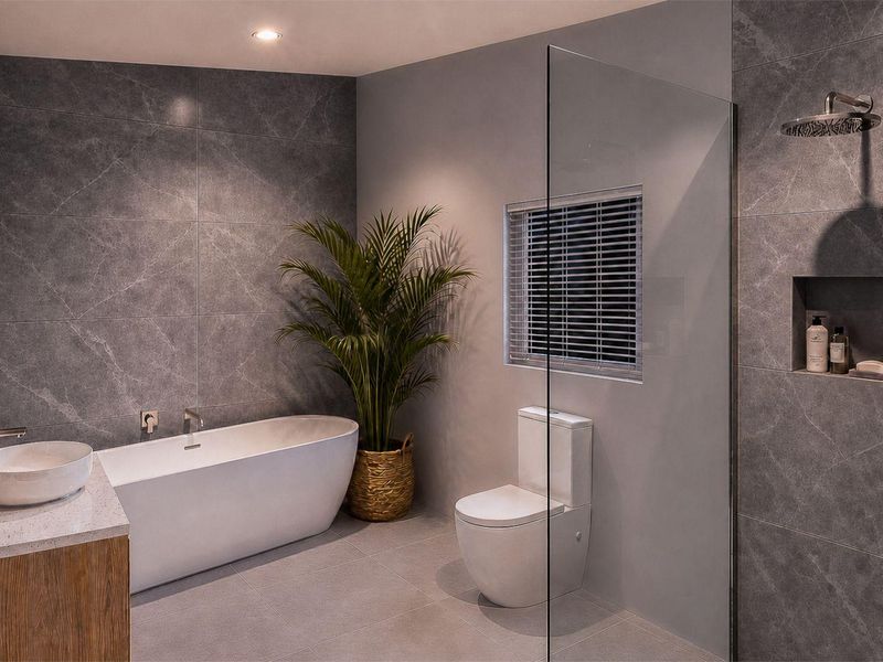 Modern bathroom featuring a freestanding bathtub, countertop basin, back-to-wall toilet, and a walk-in shower with a recessed niche and rain shower head.