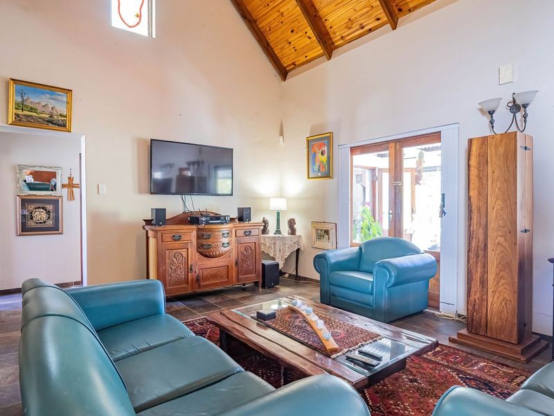 Spacious living room featuring a high vaulted timber ceiling, tiled flooring, and direct access to the outdoor area through sliding glass doors.