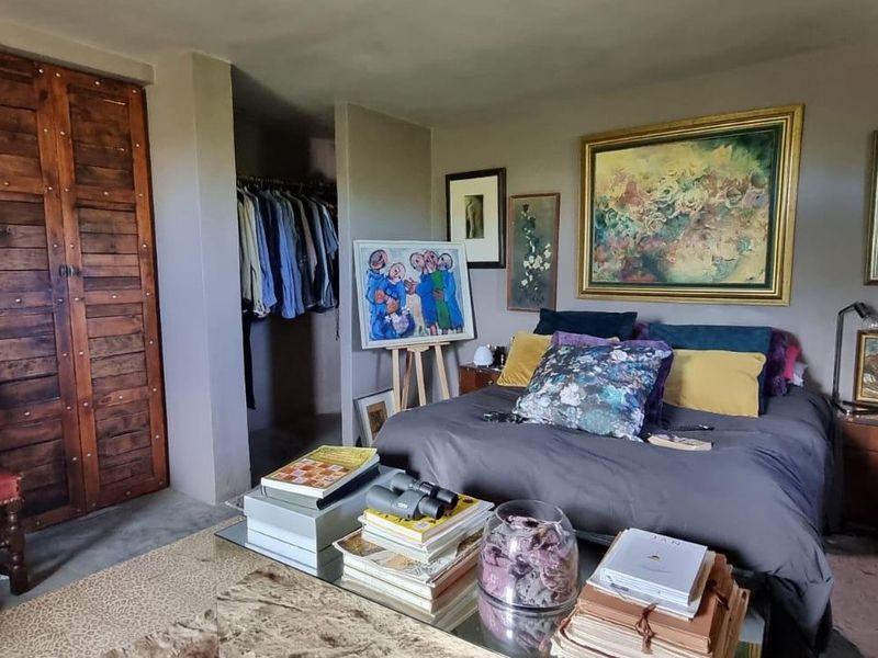 A bedroom featuring a built-in wardrobe with rustic wooden doors and an open-plan closet area.