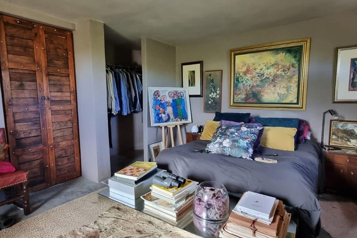 A bedroom featuring a built-in wardrobe with rustic wooden doors and an open-plan closet area.
