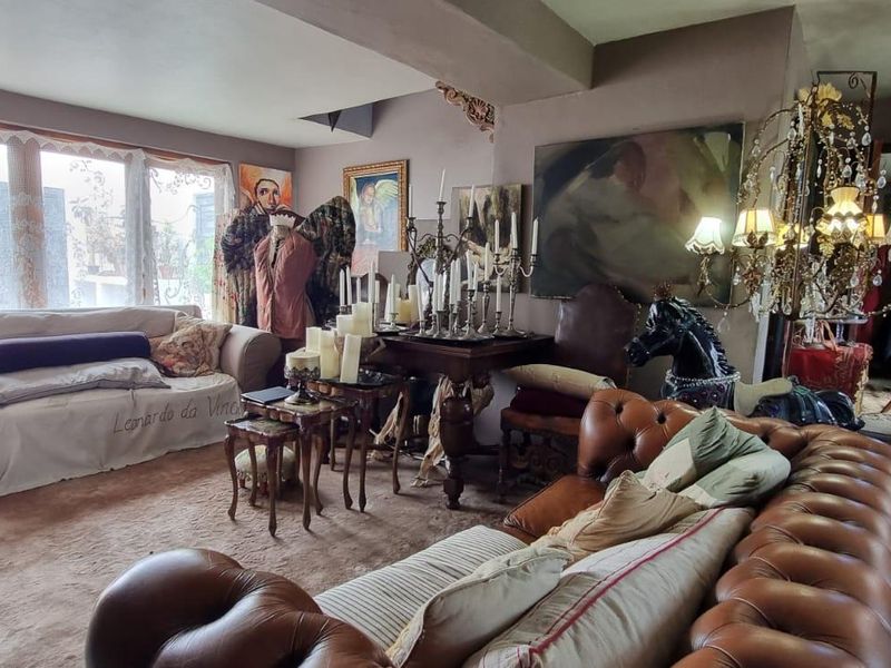 Spacious living room featuring large windows, carpeted flooring, and a coved ceiling, offering a comfortable and traditional living space.