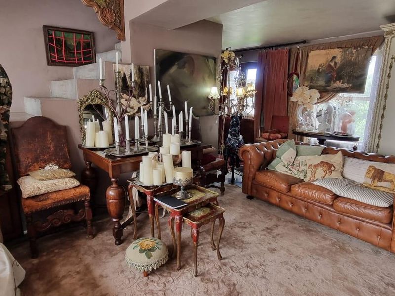 A living room area featuring a staircase and carpeted flooring, offering a traditional layout with potential for modernization.