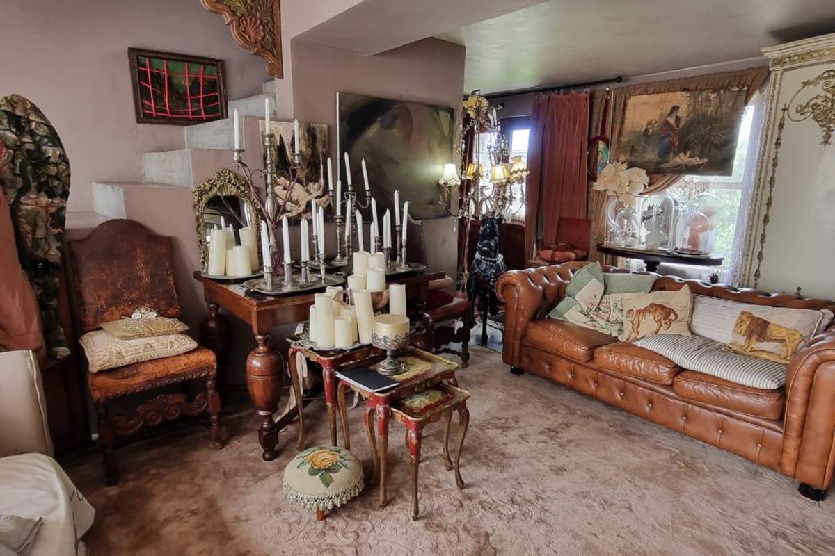 A living room area featuring a staircase and carpeted flooring, offering a traditional layout with potential for modernization.