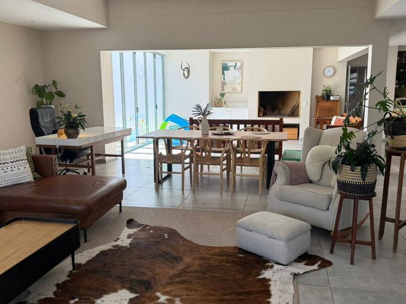 Spacious open-plan living and dining area featuring tiled floors, a built-in fireplace, and large sliding glass doors leading to the outdoor space.
