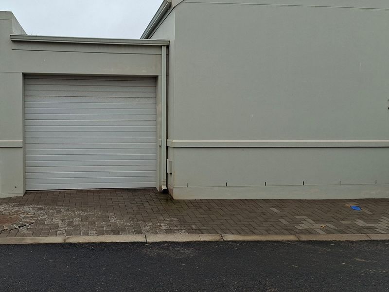Front exterior view of the property featuring a single garage door and paved driveway area.