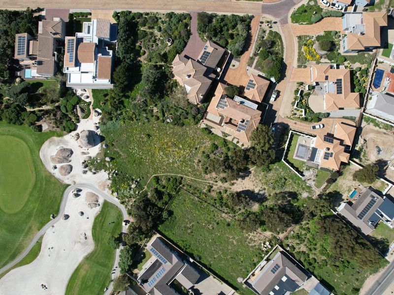 Aerial view of a vacant residential plot situated within an established estate, featuring direct access and views of the adjacent golf course.