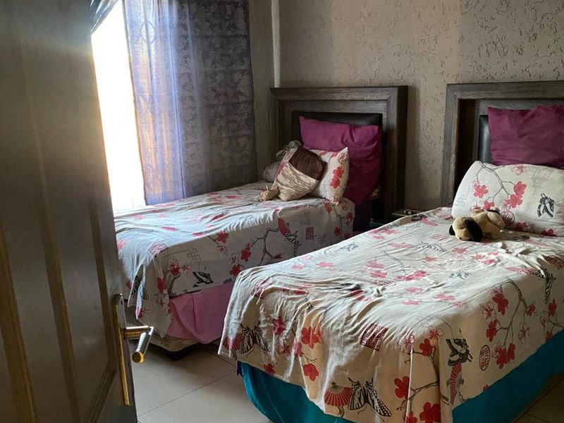 A bedroom featuring tiled flooring, textured wall finishes, and decorative cove cornicing.
